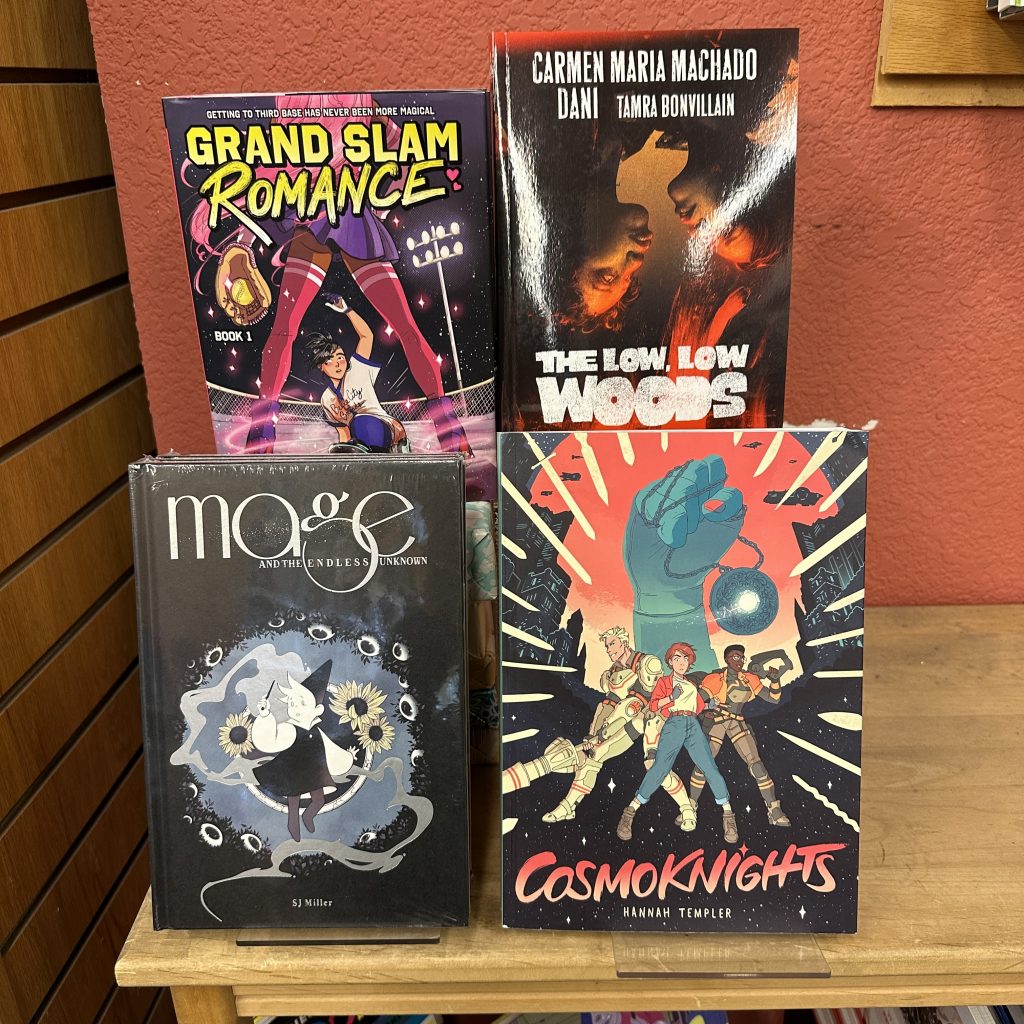 Four graphic novels recommended by Mo on a wooden table display. 