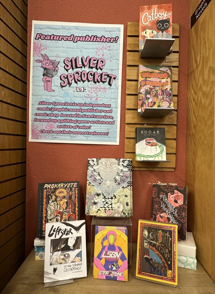 A featured section with Silver Sprocket books displayed prominently. Text on the top-left flyer reads: Featured publisher! Silver Sprocket is an independent comic/graphic novel publisher and comic shop located in San Francisco, focused on uplifting queer artists and artists of color! Check out their newest releases!