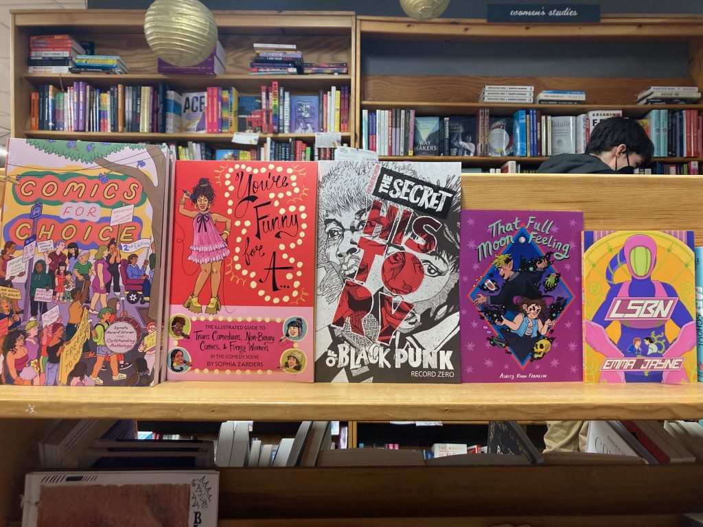 A Silver Sprocket themed shelf featuring "Comics For Choice", "You're Funny For A...", "The Secret History of Black Punk", "That Full Moon Feeling", and "LSBN".